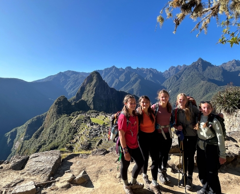 teenage girls standing in front of machu picchu in peru on teen summer camp