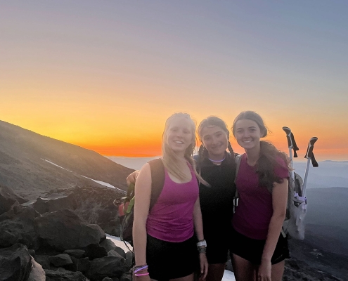three teenage girls standing on mount st helens as they hike to the summit on teen adventure camp