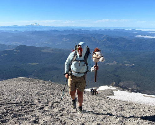 teenage boy hiking up mount st helens in a blue long-sleeve shirt