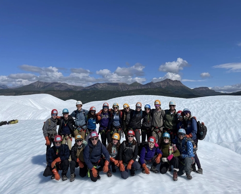 Group of teens in ice climbing gear posting for a picture on the Matanuska Glacier in Alaska