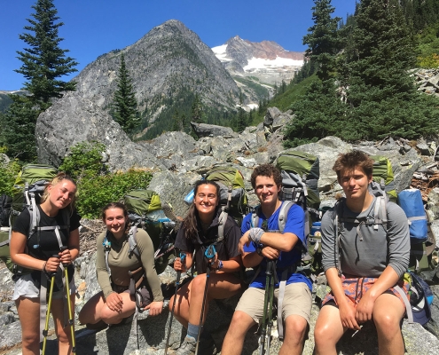 group of teen students on an outdoor adventure gap semester trip in the mountains