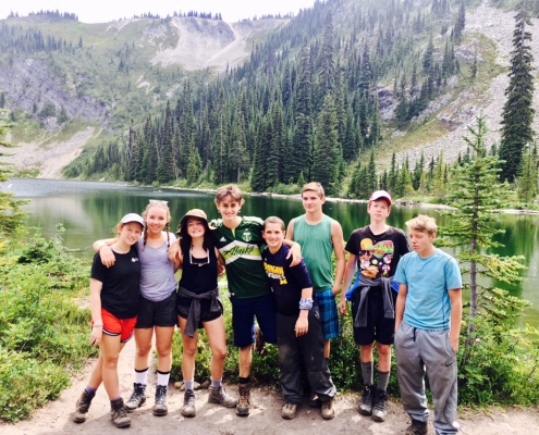 outdoor adventure camp students standing infront of mountains at summer teen adventure camp