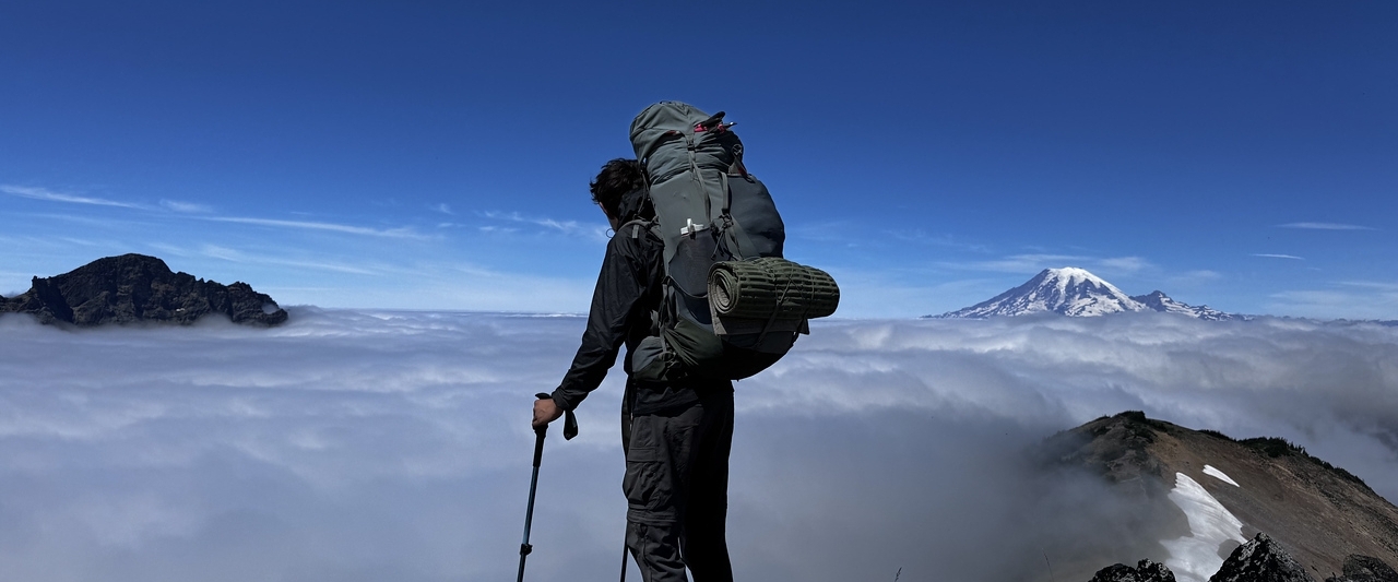 teen boy hiking and climbing a mountain at summer camp in washington state teen boy hiking and climbing a mountain at summer camp in washington state