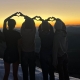 Teen girls standing with their hands creating a heart shape on Mt. Lassen in California