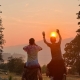 Teen boys sitting on each other's shoulders enjoying a sunset view in Washington